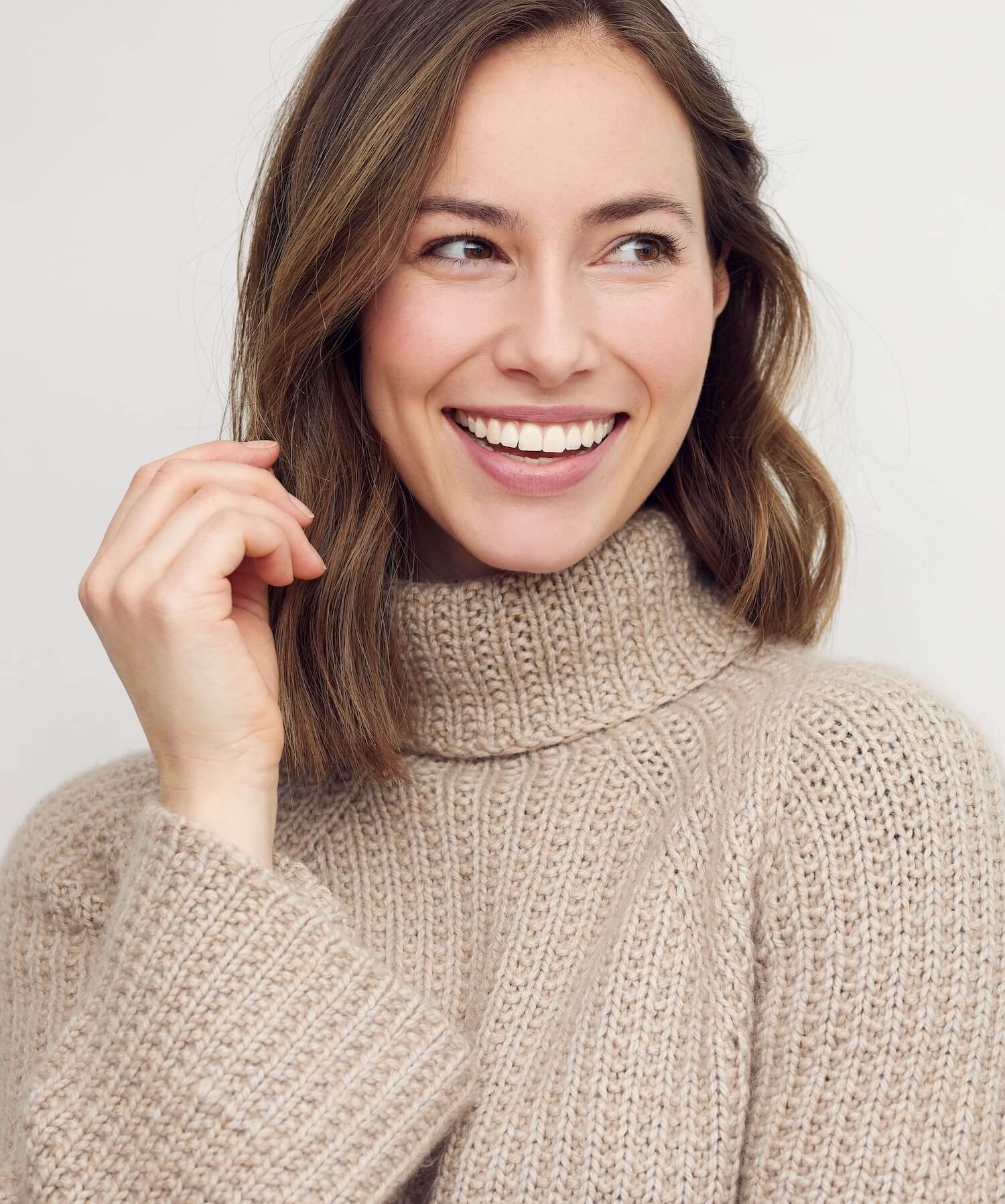 Photo of a brunette woman wearing a sweater