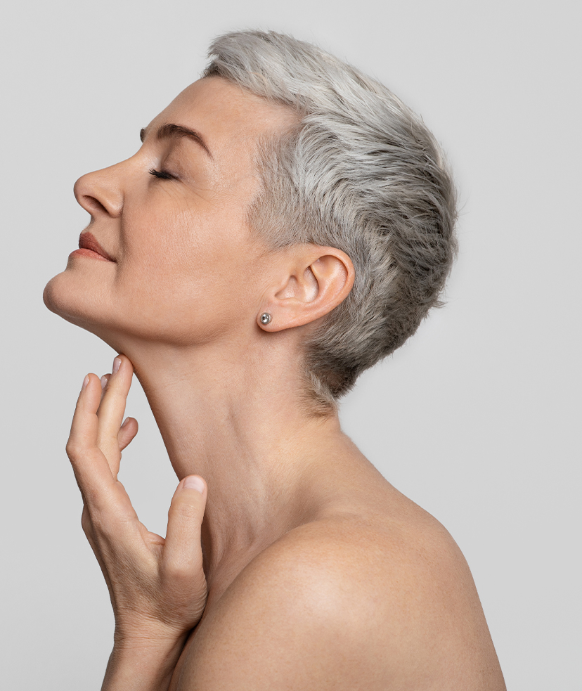 Photo of an older woman with short hair touching her neckline